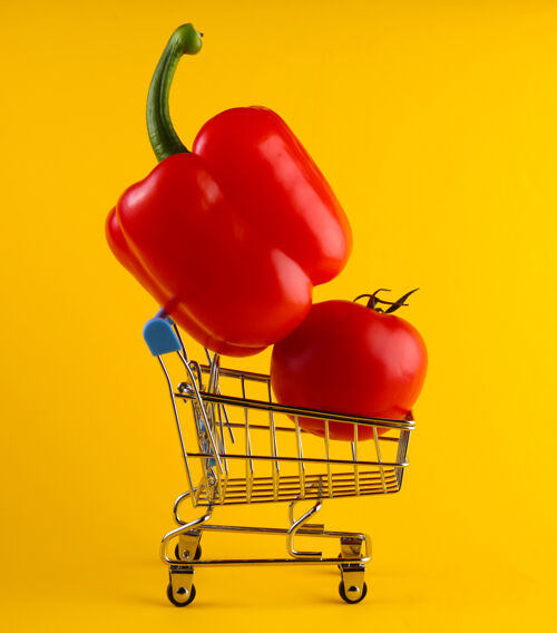 金属黄色上有甜椒和西红柿的购物车买顾客超市