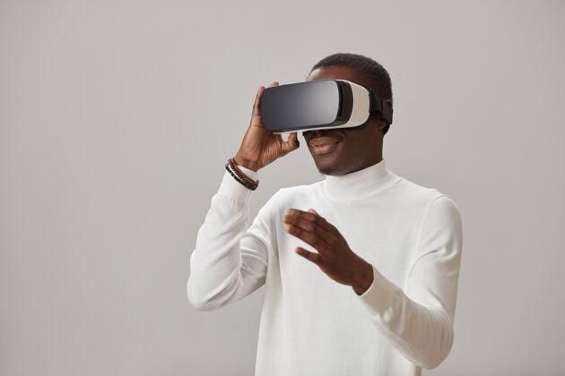 眼镜戴着虚拟现实眼镜的年轻人 对着墙玩虚拟游戏蓝牙触摸成人