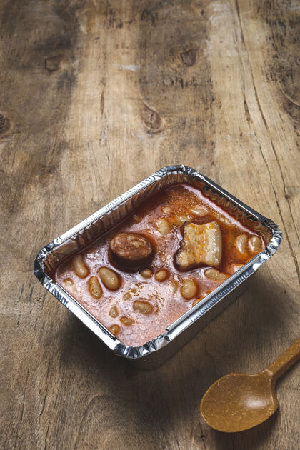 午餐盒放在铝制容器里的豌豆 香肠和肉餐桌食品送货炖肉容器外卖