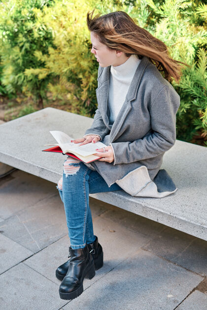 模特一个蓝眼睛的白人金发年轻女子在公园看书女性金发成人