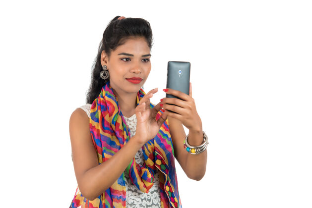 通话年轻的印度女孩用手机或智能手机隔离在一个白色的表情女性空白