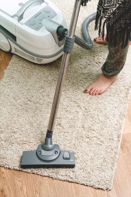 家庭主妇用吸尘器清理地毯的女人清洁新成人