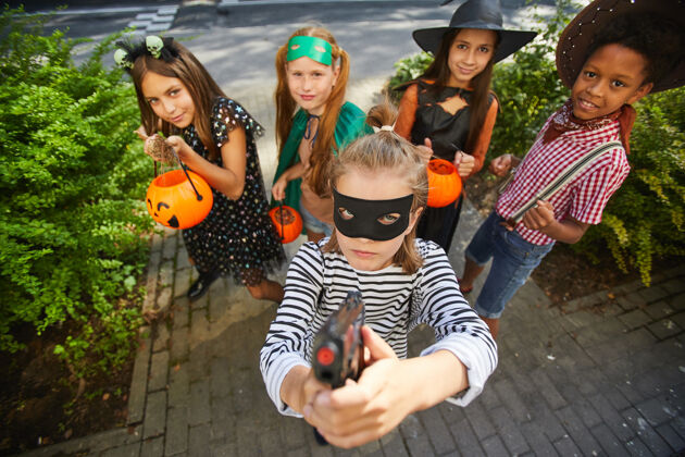 杰克o灯笼一群穿着万圣节服装的孩子在节日里玩“不给糖就捣蛋”游戏 他们站在户外对着镜头微笑南瓜十月游戏