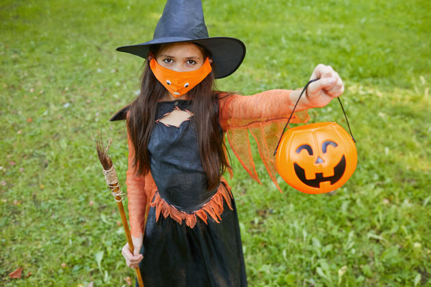 蜘蛛穿着女巫服装的小女孩站在户外 抱着篮子 请求款待的画像季节神秘孩子