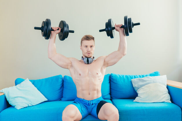 健康运动员在家健身用哑铃男人身体专注