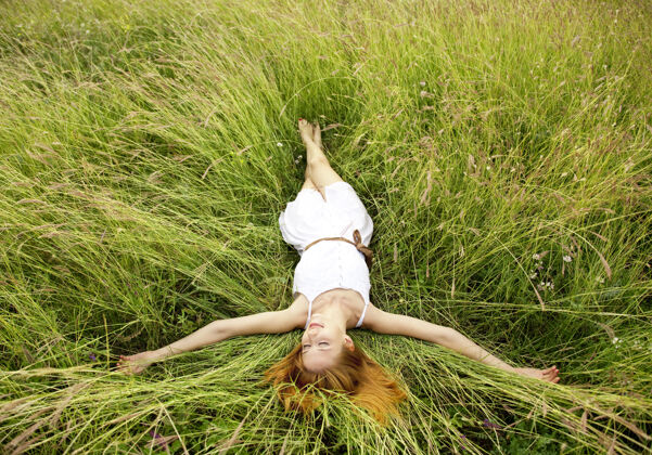 红发躺在草地上的漂亮女孩梦想户外绿色