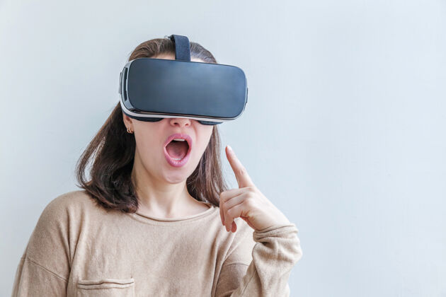 网络微笑的年轻女子戴着虚拟现实vr眼镜头盔耳机在白色背景上娱乐护目镜3d