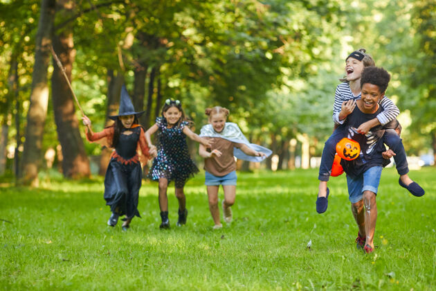 运动万圣节派对期间 一群快乐的朋友一起在公园里玩耍玩耍玩耍白天