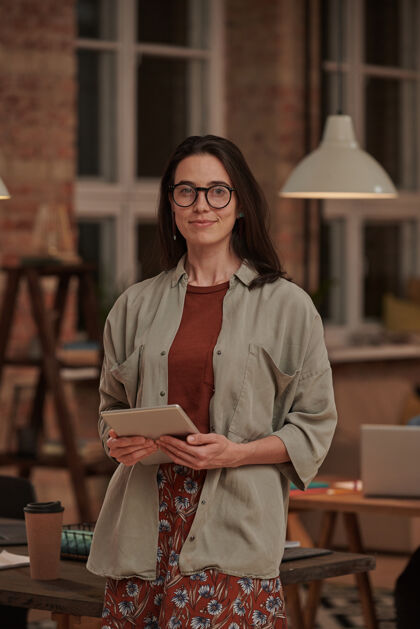 人员戴着眼镜 手持平板电脑的年轻女商人在办公室前微笑的画像微笑无线技术站立