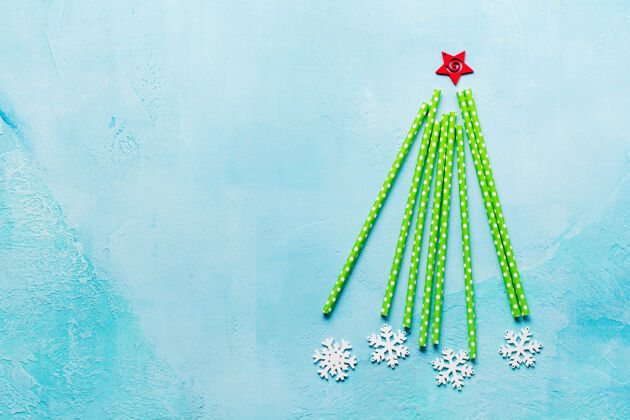 糖果圣诞树是用彩色的纸做成的 蓝色的表面有白色的棉花糖和雪花玩具五彩庆祝公告