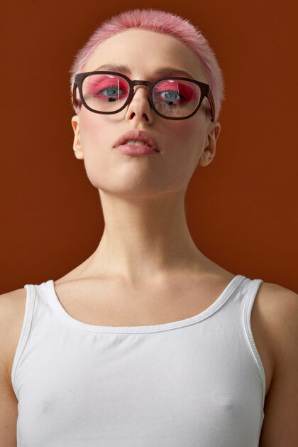 发型一个时髦的年轻女子与粉红色短发正面肖像粉色头发女人姿势