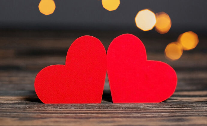 图书馆一对红心放在灯的背景上 爱情和情人节的概念放在木桌上木可爱表