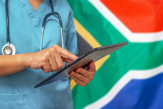 工人外科医生或医生使用南非国旗背景上的数字平板电脑检查医院职业