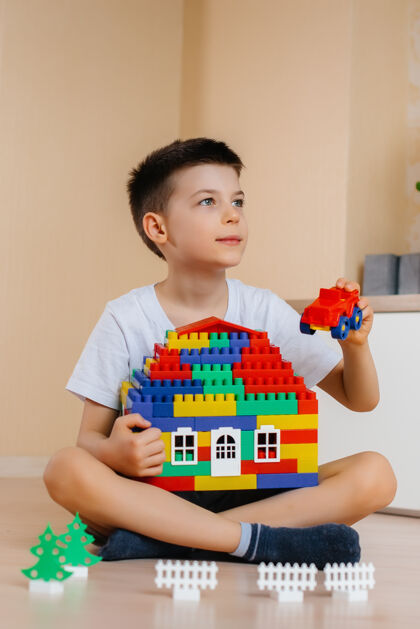 活动一个小男孩玩着一个建筑工具 为全家建造了一座大房子建造一个家庭住宅特写保护游戏
