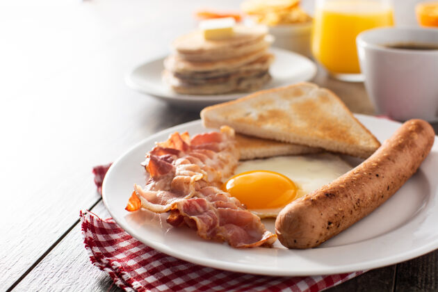 早餐传统的美式早餐 木桌上有煎蛋 吐司 培根和香肠营养欧式蛋