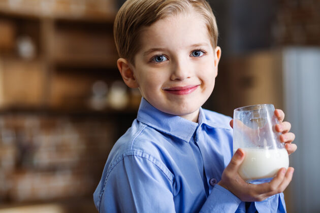 孩子喝牛奶的时候 快乐微笑的小男孩表达喜悦的特写镜头美味钙少