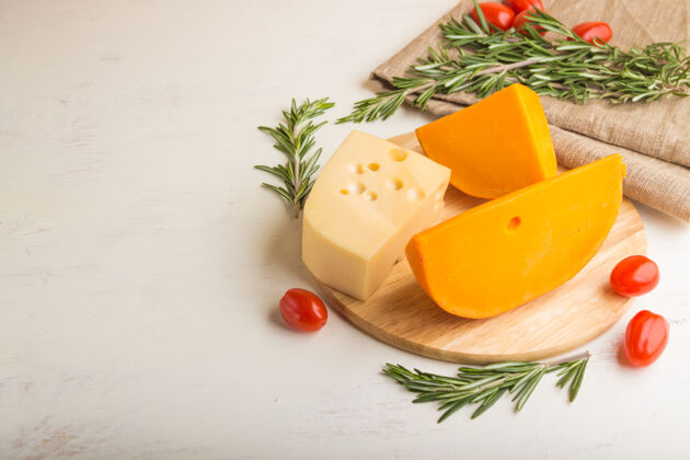 各种各种类型的奶酪与迷迭香和西红柿在木板上的白色木质表面和亚麻织物组意大利自然