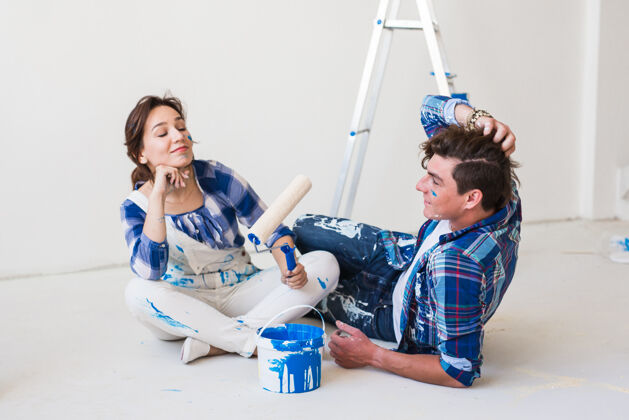 人一对年轻有趣的夫妇正在装修新公寓女工作胶水