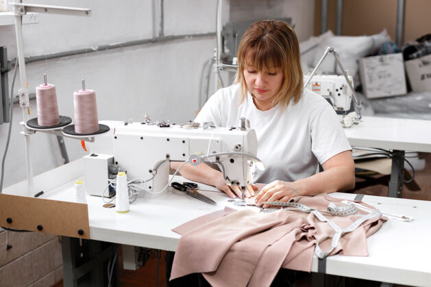 生产那个女人在工厂缝缝纫机针面料纺织品