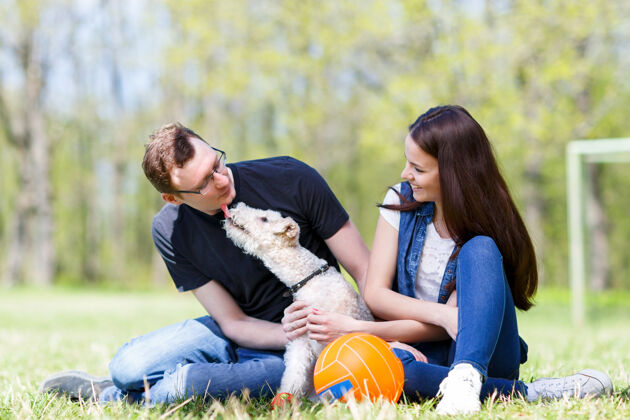 男人快乐的年轻家庭玩着狗舔主人的脸以示爱意浪漫关系年轻