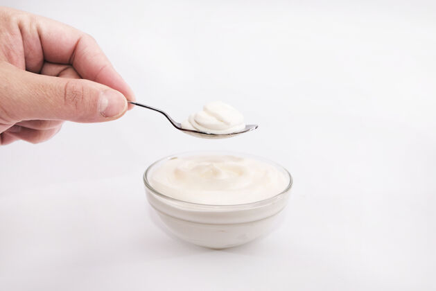 复制空间用勺子把酸奶油抹在白色上蓝色特写白色