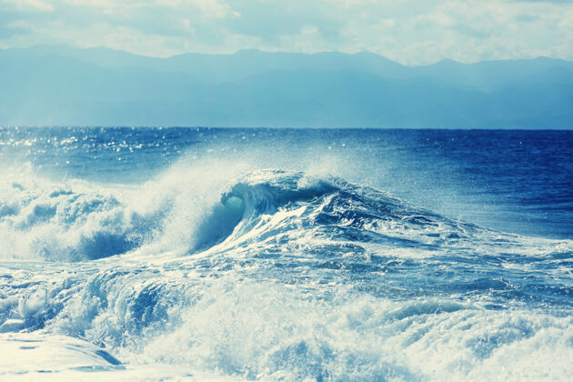 沙子海滩上的蓝色波浪自然膨胀大浪