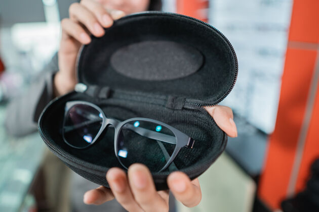 眼镜商根据客户的手的选择 手将眼镜放在眼镜架中眼科礼品验光师
