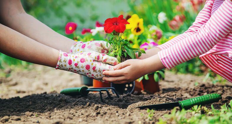 成长孩子和妈妈在花园里种花花快乐可爱