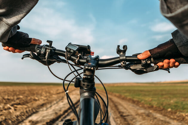 自行车手自行车在野外道路上从骑自行车的人的眼睛看运动休闲车把
