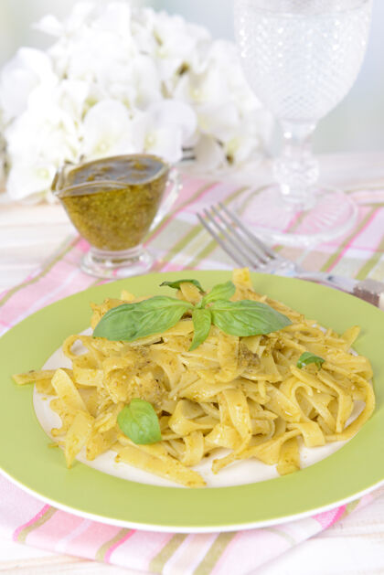 橄榄美味的意大利面和香蒜酱放在盘子里放在桌子上放在灯下香草意大利面水