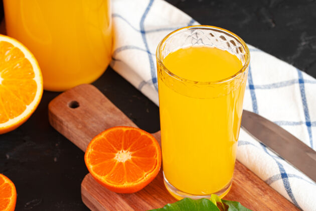 有机木桌上橙汁杯的特写镜头提神果汁早餐