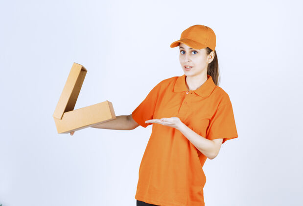 运输身着橙色制服的女快递员手里拿着一个打开的纸板箱 看上去既困惑又体贴订单工人服装