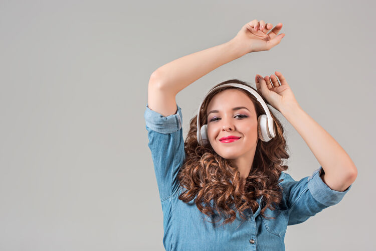 肖像快乐的年轻女子用耳机听音乐头发人物耳机