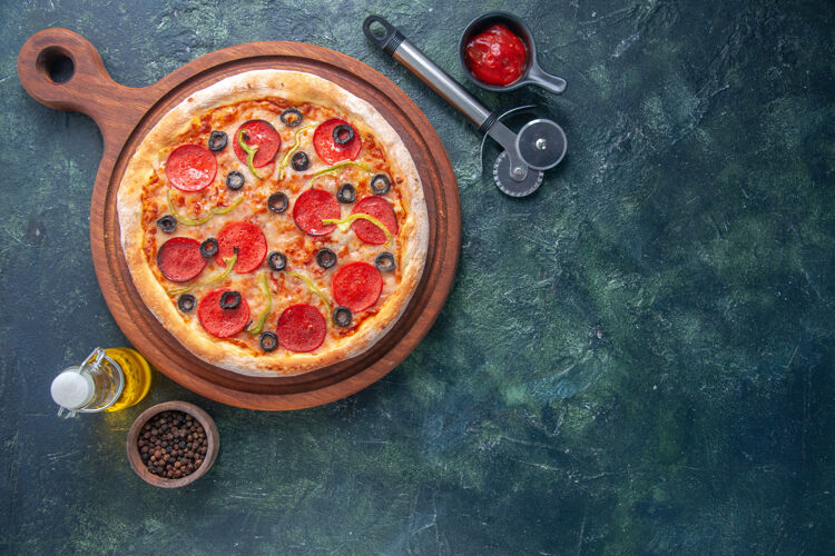 橄榄美味的自制披萨在木板上番茄和油瓶辣椒番茄酱在黑暗的表面右侧板奶酪晚餐