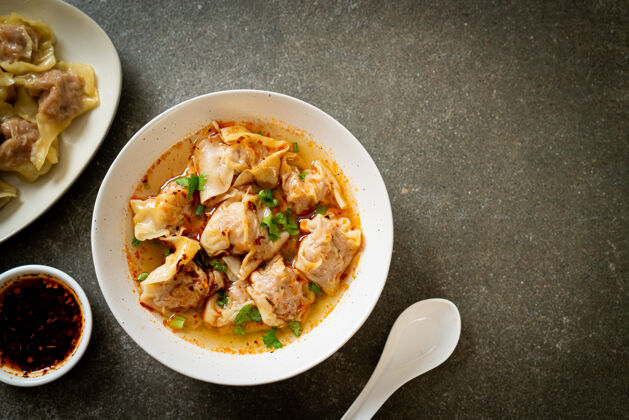 东方菜猪肉馄饨汤或猪肉饺子汤配烤辣椒-亚洲风味碗肉开胃菜