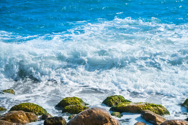 海海边有石头 冲浪的背景是海浪风景黎明海滩