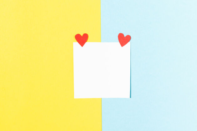 顶视图情人节贺卡白色正方形 蓝色和黄色背景上有红色心形的便笺信件彩色浪漫