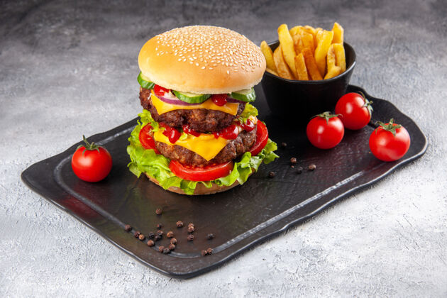 晚餐美味的自制三明治和油炸番茄酱在灰色冰面上的黑板上食物晚餐奶酪