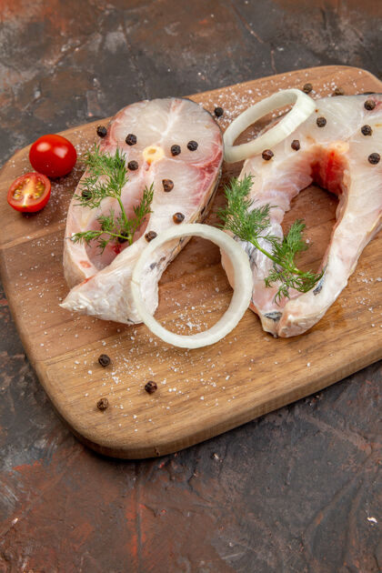 板特写镜头新鲜生鱼和胡椒洋葱绿色西红柿在木砧板上混合颜色的表面射击午餐洋葱