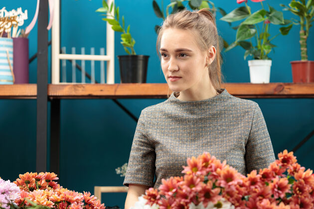 业主花匠做了一束五颜六色的菊花一个年轻的成年女孩向旁边看优雅站高加索人种