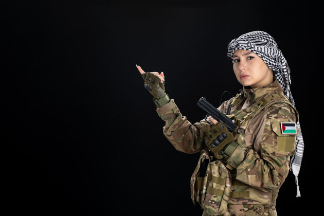 衣服穿军装的女兵在黑墙上持枪女兵人肖像