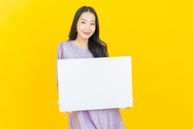表一个年轻的亚洲女人拿着黄色的白色广告牌女性中国人标语牌