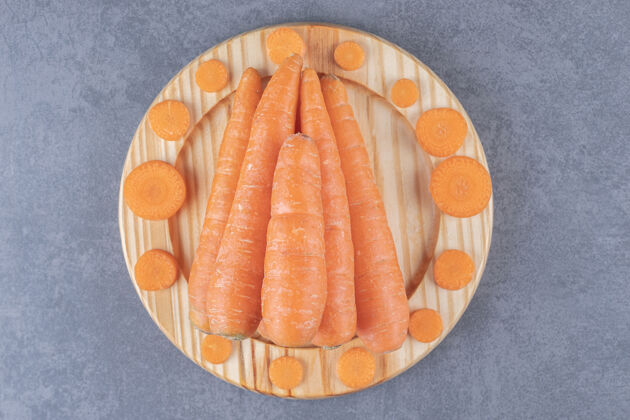生的整个胡萝卜和切片在木板上 在大理石表面美味美味蔬菜
