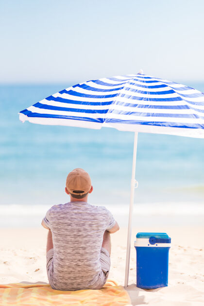 海湾夏日阳伞下沙滩上年轻胡须男的画像旅行自然海洋