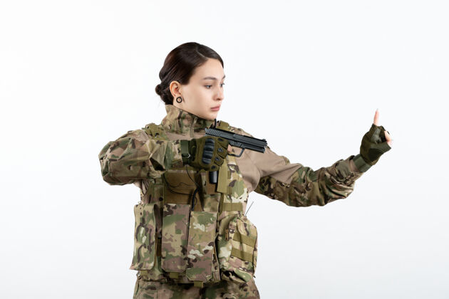 战争前视图：白墙上带枪的伪装女兵肖像私人战士