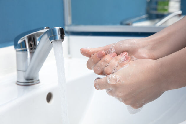 泡沫用肥皂和消毒剂仔细洗手的女人 闭嘴肥皂浴室水槽
