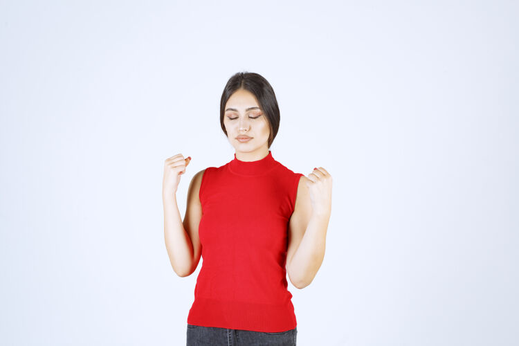 模特穿红衬衫的女孩展示她的手臂肌肉和拳头幸运动力女人