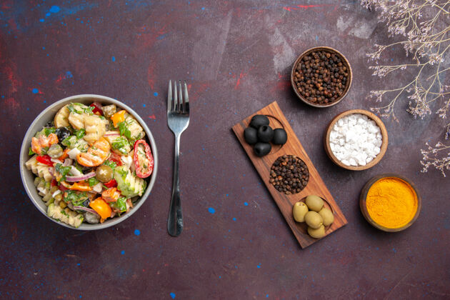 烹饪俯瞰美味的蔬菜沙拉与不同的调味品对黑暗的背景健康沙拉餐饮食胡椒粉沙拉食物