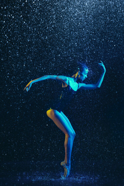 瘦年轻的女芭蕾舞演员在水滴和浪花下表演白种人模特在霓虹灯下跳舞迷人的女人芭蕾舞和当代舞蹈概念创意艺术照片喷雾芭蕾舞演员舞蹈