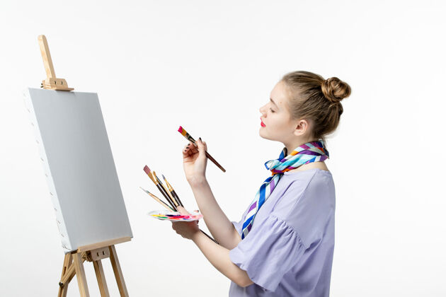孩子前视图女画家准备在白墙上绘画艺术图片摄影艺术家画架铅笔小学生视图女画家